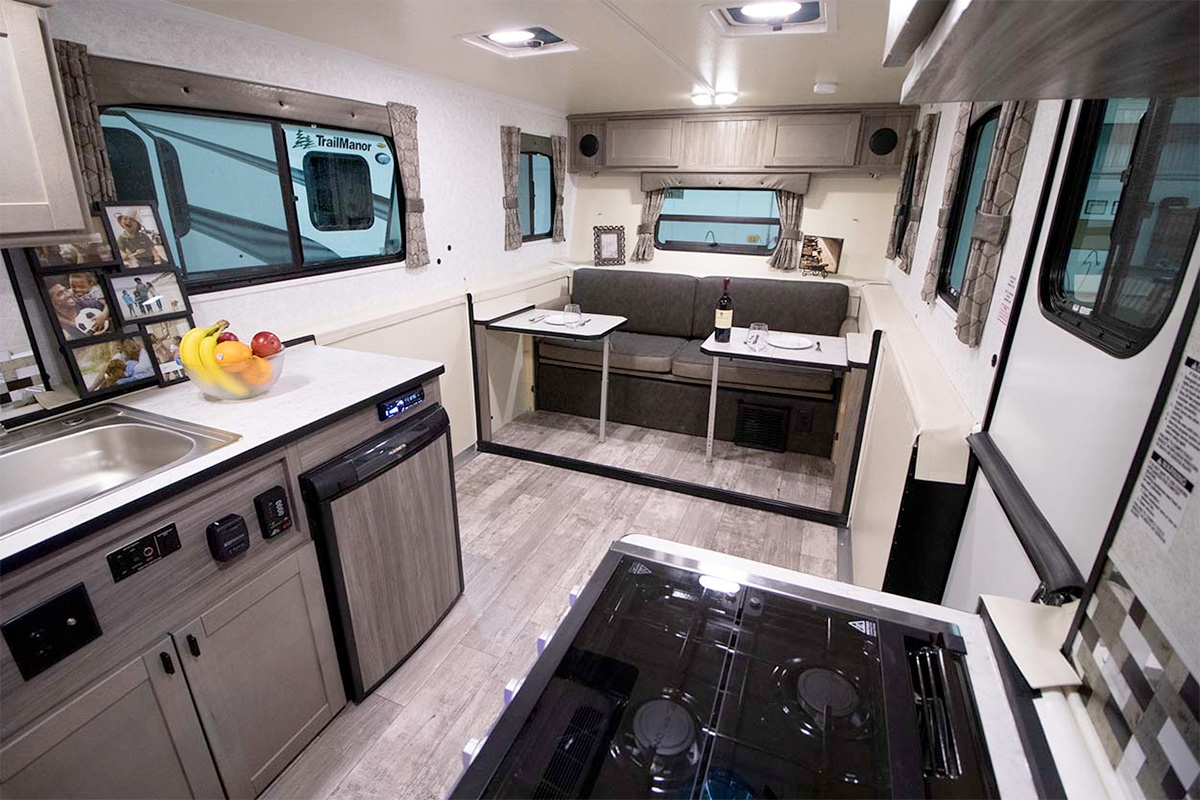 TrailManor features a fully-equipped kitchen and a versatile dinette that converts into additional sleeping space.