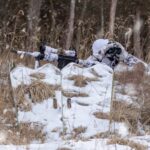 Hunter concealed behind a GhostBlind mirrored hunting blind in a snowy field